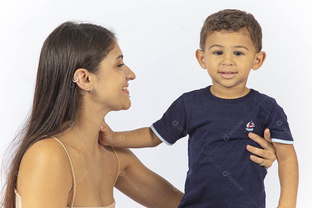 Mãe sentada no chão de frente para o filho sobre um fundo branco.