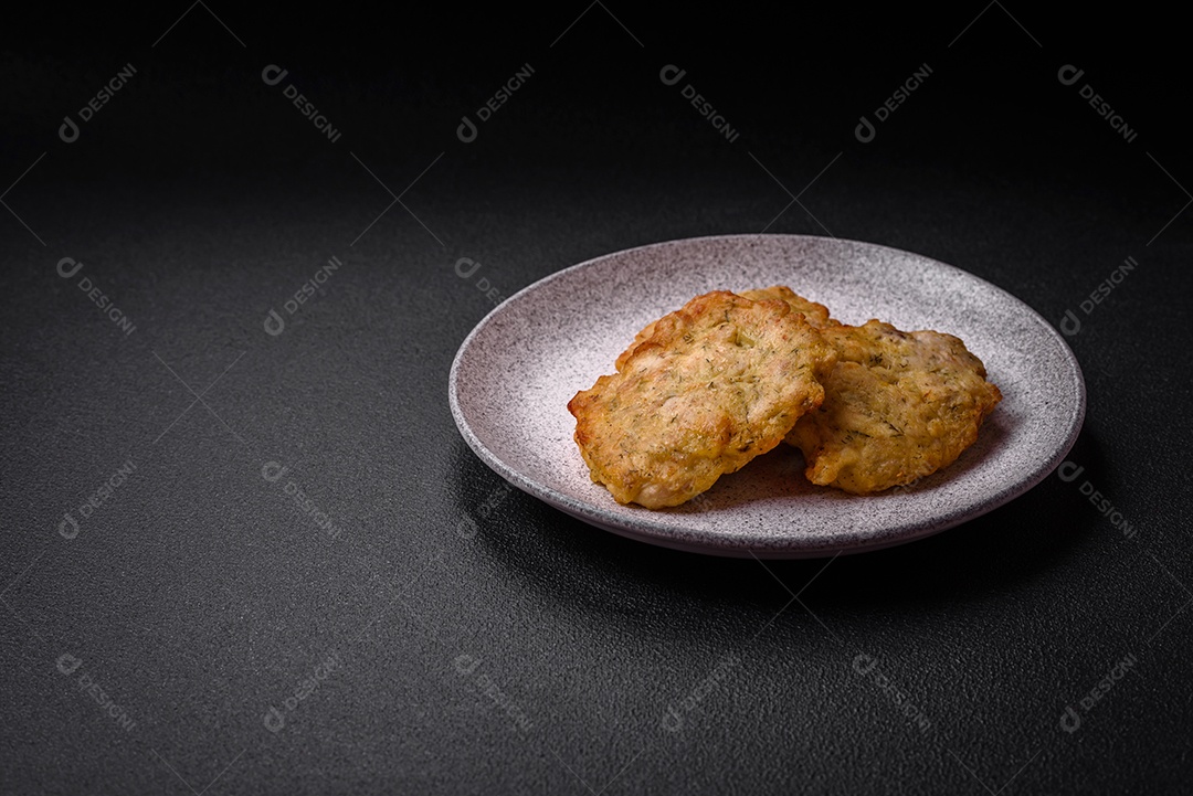 Delicioso frango frito suculento ou panquecas de porco com sal, especiarias e ervas sobre um fundo escuro de concreto