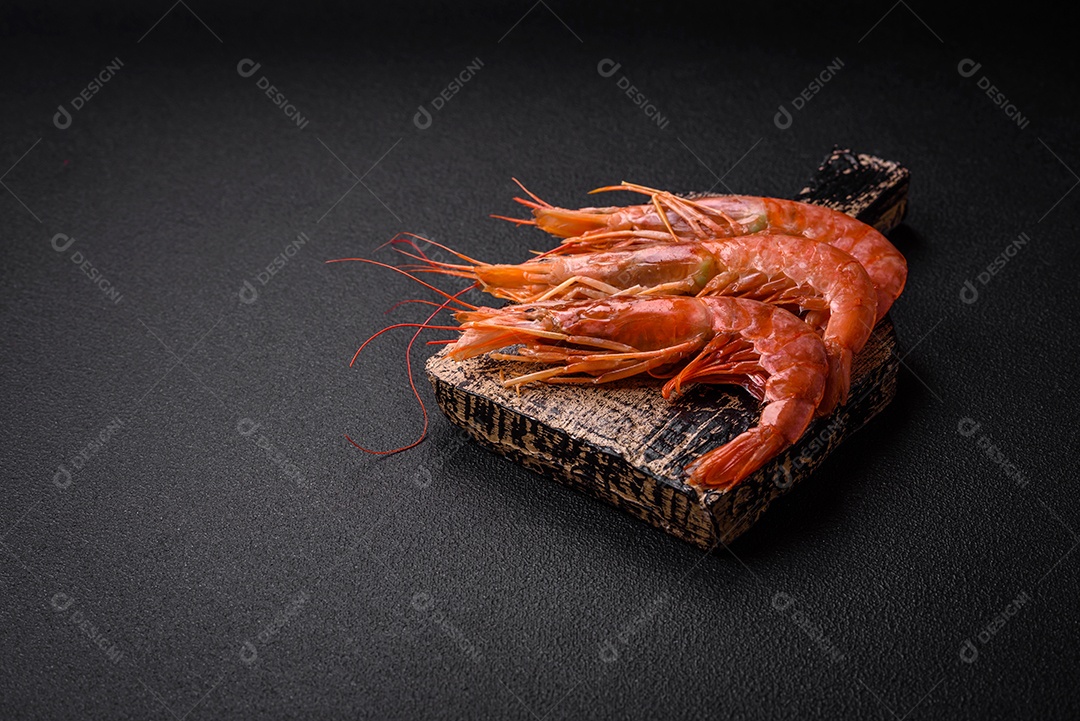 Camarão tigre ou lagostim fervido com especiarias e sal sobre um fundo escuro de concreto
