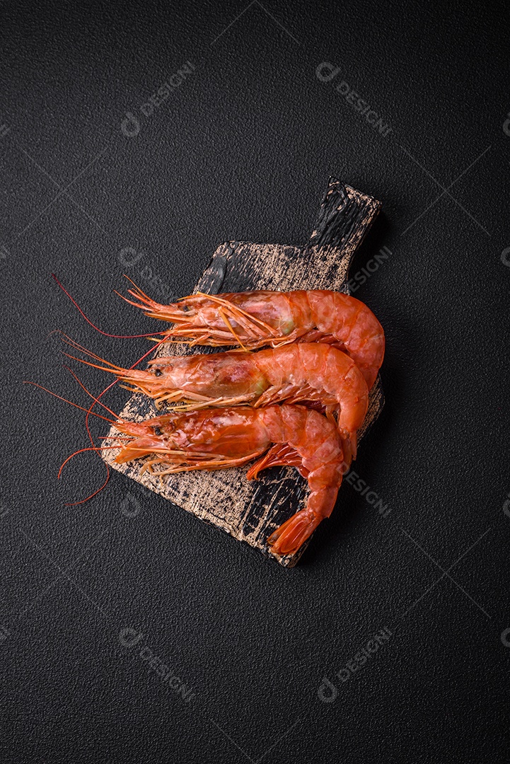 Camarão tigre ou lagostim fervido com especiarias e sal sobre um fundo escuro de concreto