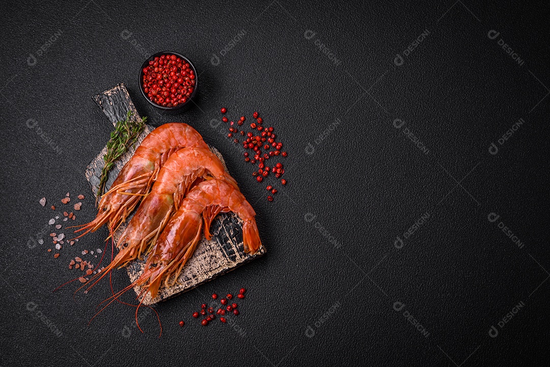 Camarão tigre ou lagostim fervido com especiarias e sal sobre um fundo escuro de concreto