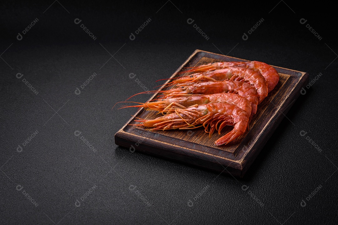 Camarão tigre ou lagostim fervido com especiarias e sal sobre um fundo escuro de concreto