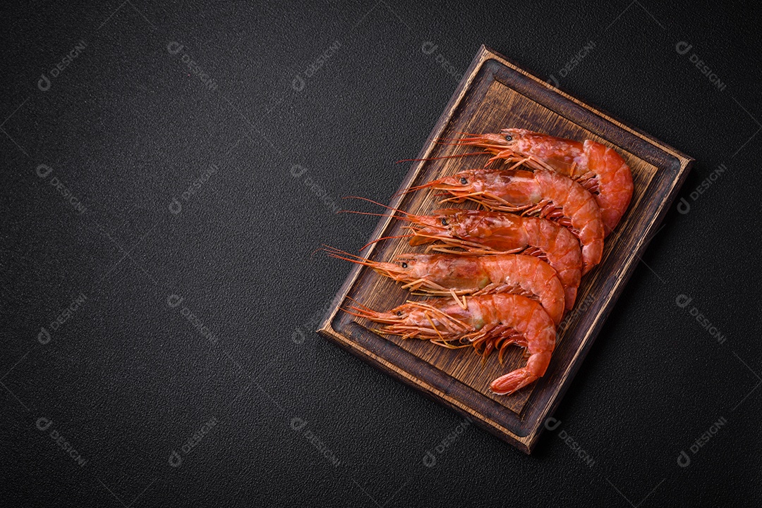 Camarão tigre ou lagostim fervido com especiarias e sal sobre um fundo escuro de concreto