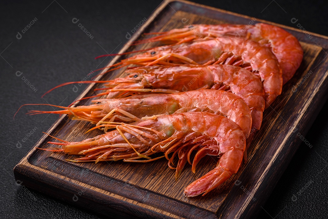 Camarão tigre ou lagostim fervido com especiarias e sal sobre um fundo escuro de concreto