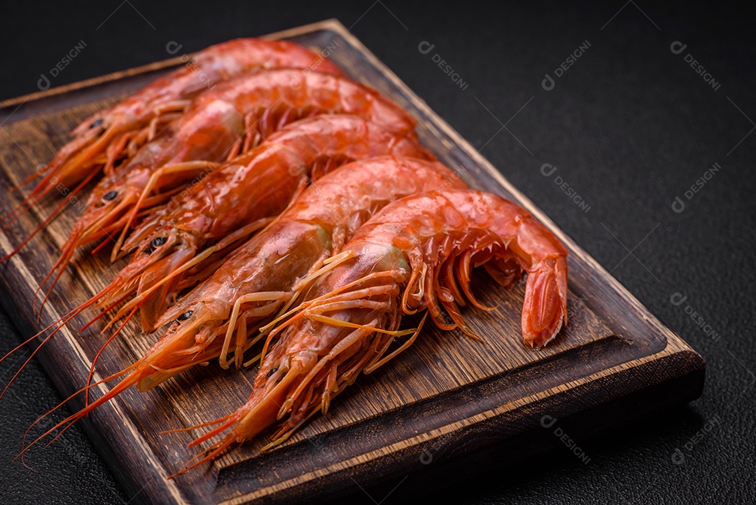 Camarão tigre ou lagostim fervido com especiarias e sal sobre um fundo escuro de concreto