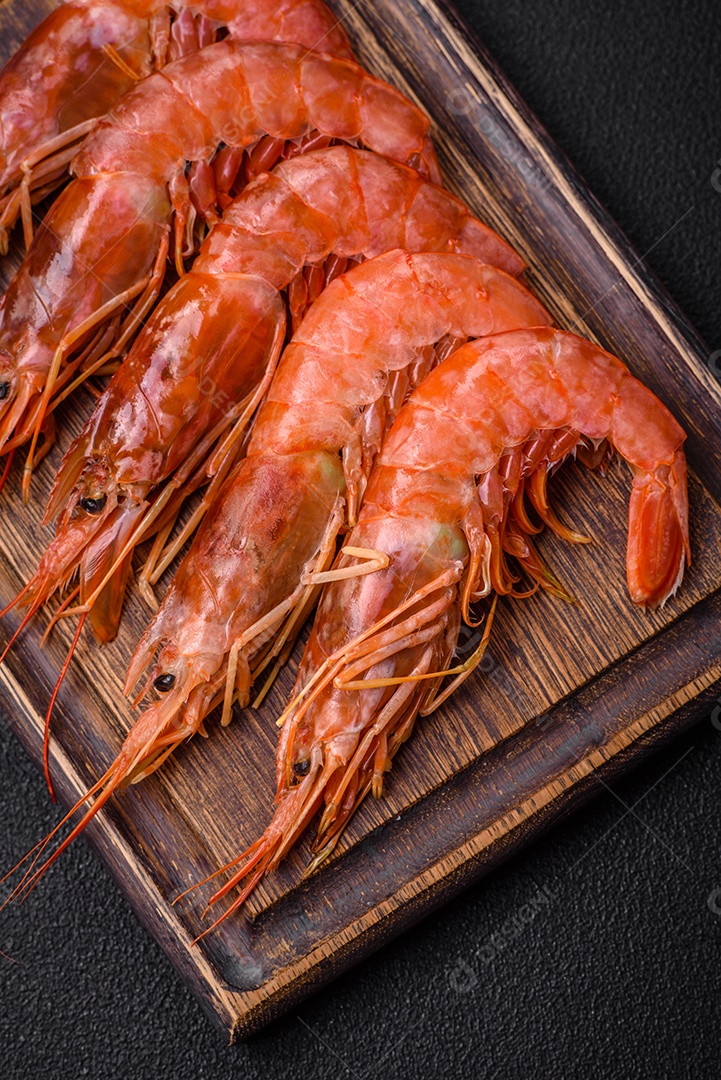 Camarão tigre ou lagostim fervido com especiarias e sal sobre um fundo escuro de concreto