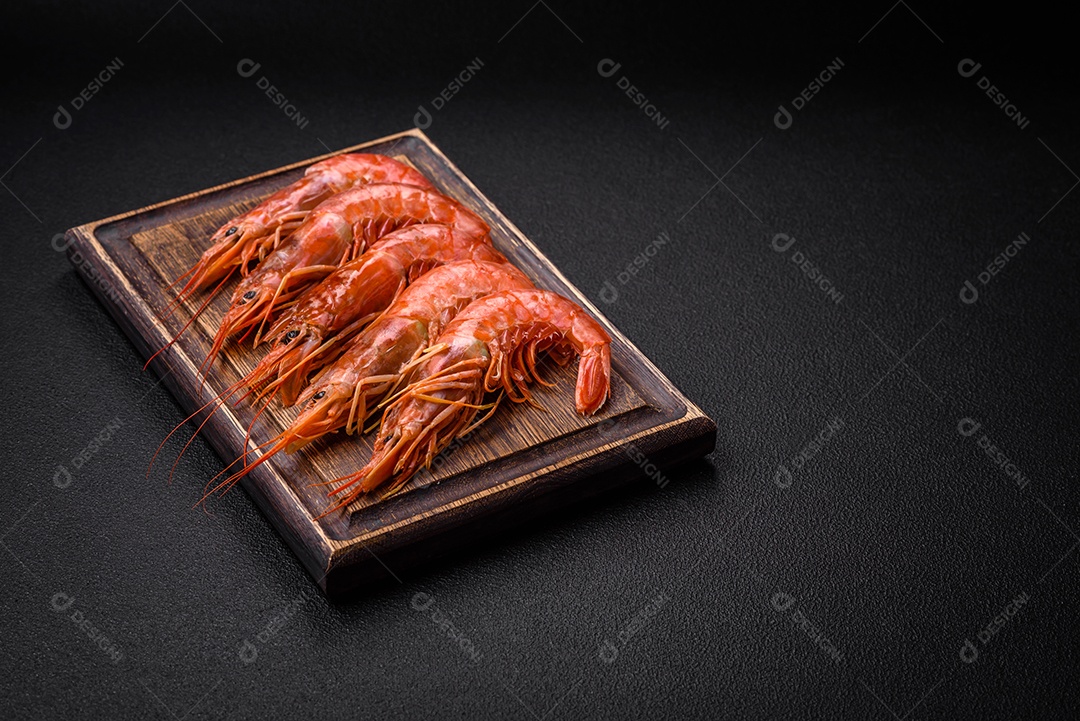 Camarão tigre ou lagostim fervido com especiarias e sal sobre um fundo escuro de concreto