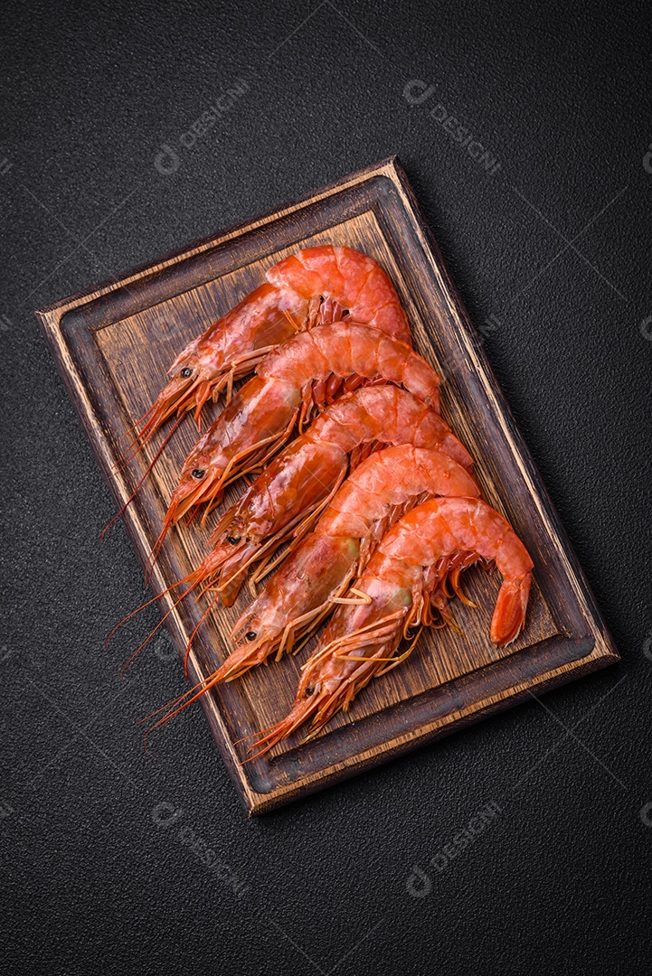 Camarão tigre ou lagostim fervido com especiarias e sal sobre um fundo escuro de concreto