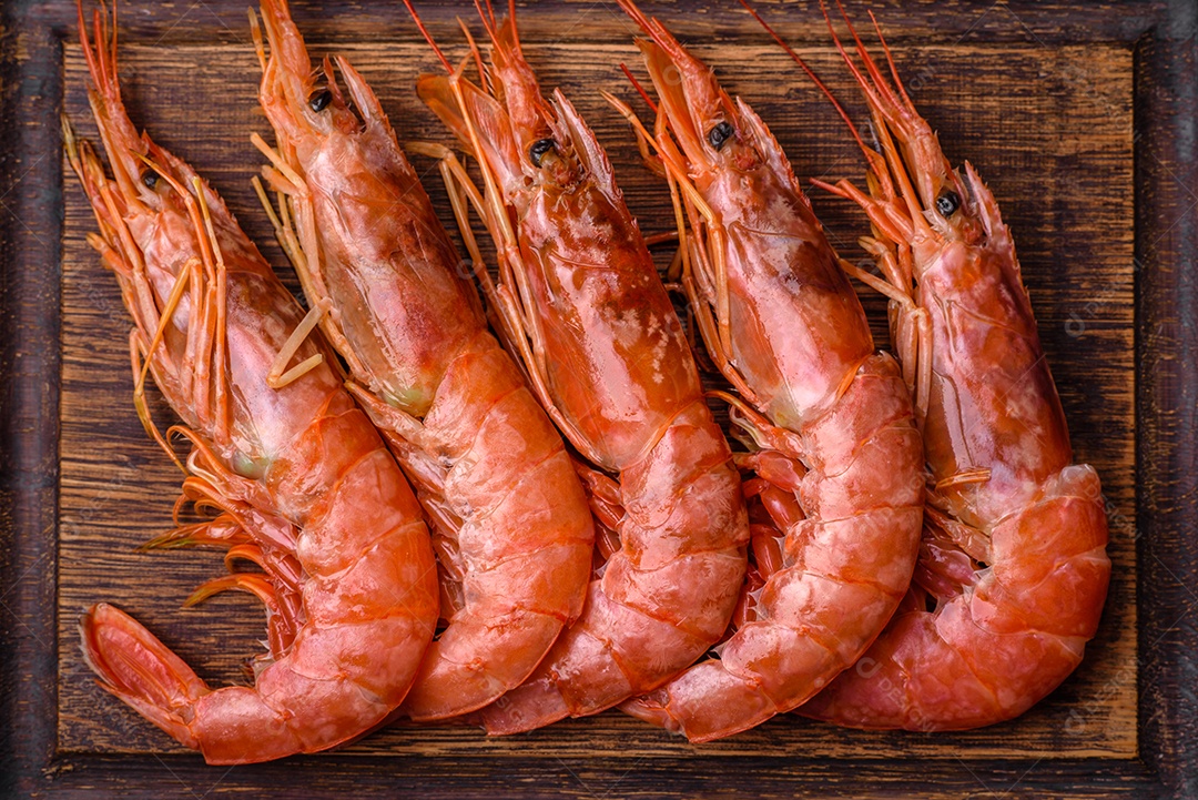 Camarão tigre ou lagostim fervido com especiarias e sal sobre um fundo escuro de concreto