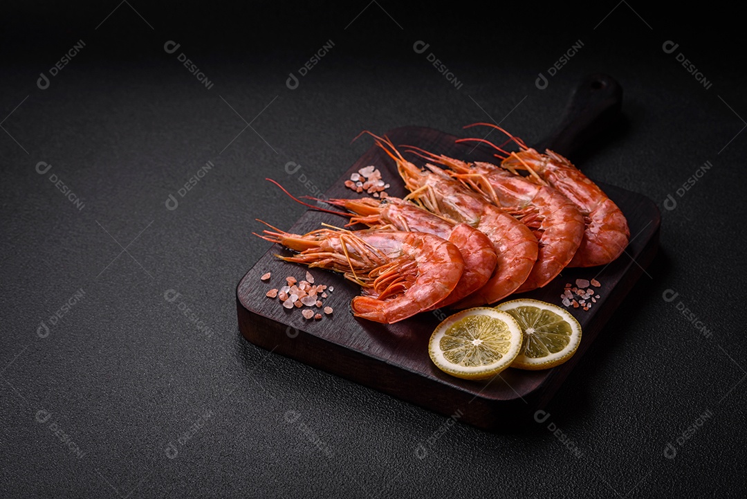 Camarão tigre ou lagostim fervido com especiarias e sal sobre um fundo escuro de concreto