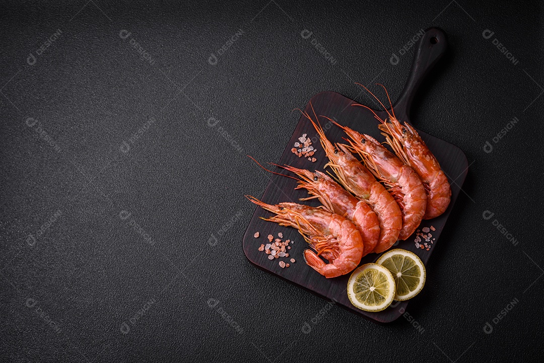 Camarão tigre ou lagostim fervido com especiarias e sal sobre um fundo escuro de concreto