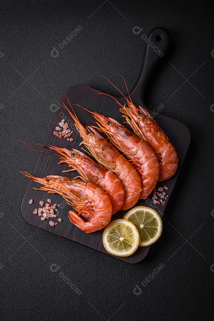Camarão tigre ou lagostim fervido com especiarias e sal sobre um fundo escuro de concreto