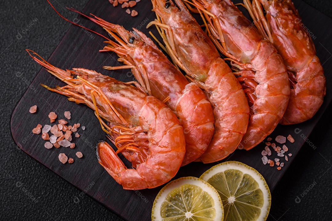 Camarão tigre ou lagostim fervido com especiarias e sal sobre um fundo escuro de concreto