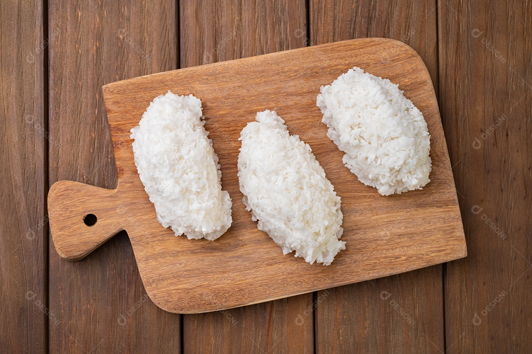 Cocada tradicional doce de coco com coco ralado isolado sobre fundo de madeira