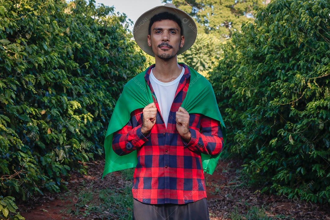 Agricultor em plantação de café segurando uma bandeira brasileira