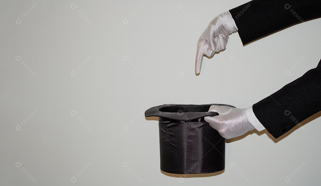 Jovem mágico ilusionista negro fazendo mágica com uma cartola e uma varinha mágica