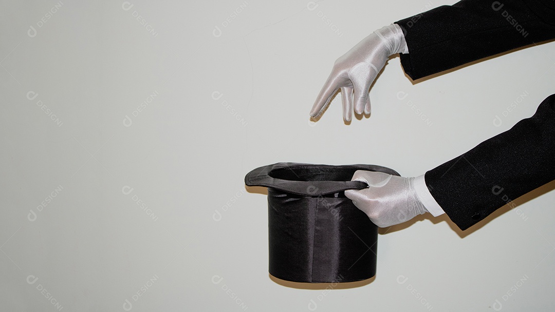 Jovem mágico ilusionista negro fazendo mágica com uma cartola e uma varinha mágica