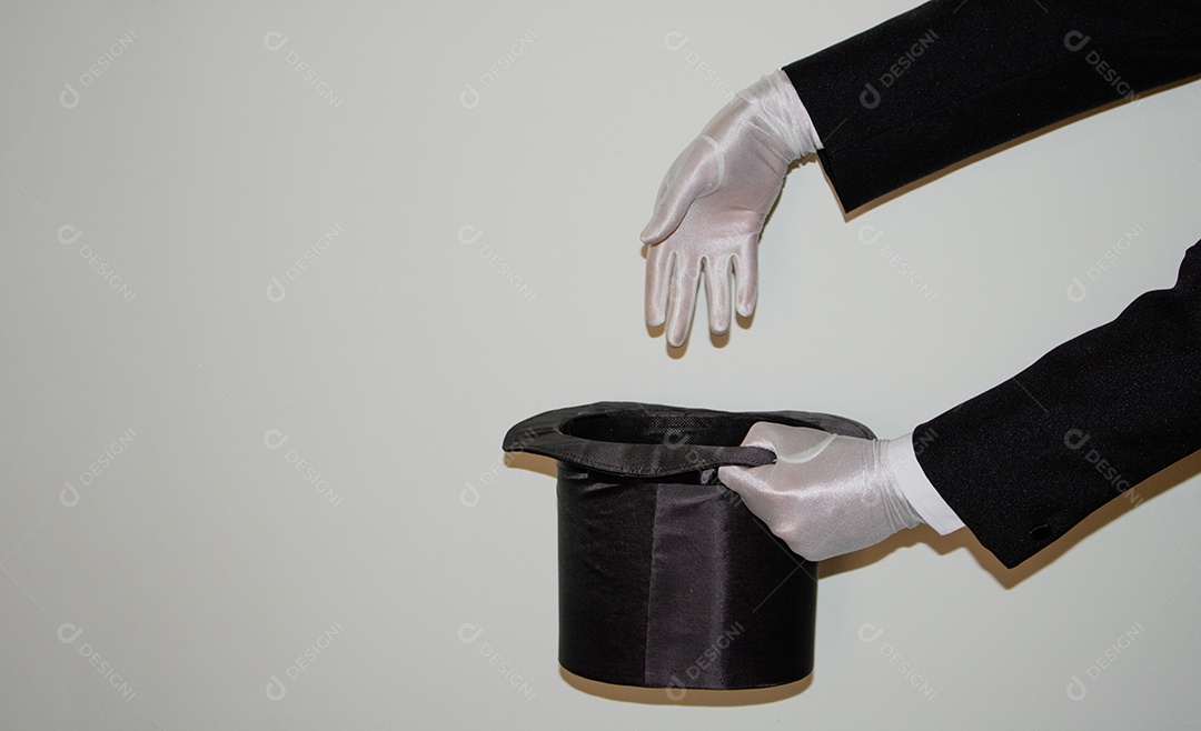 Jovem mágico ilusionista negro fazendo mágica com uma cartola e uma varinha mágica