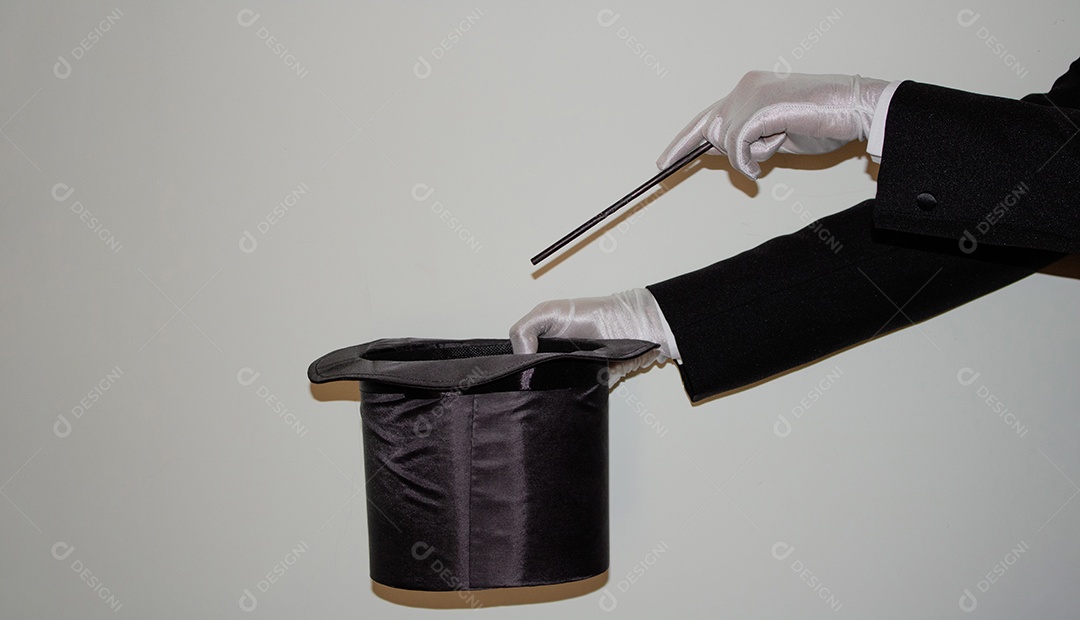 Jovem mágico ilusionista negro fazendo mágica com uma cartola e uma varinha mágica