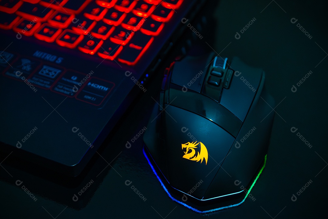 Teclado de laptop com iluminação vermelha e mouse preto