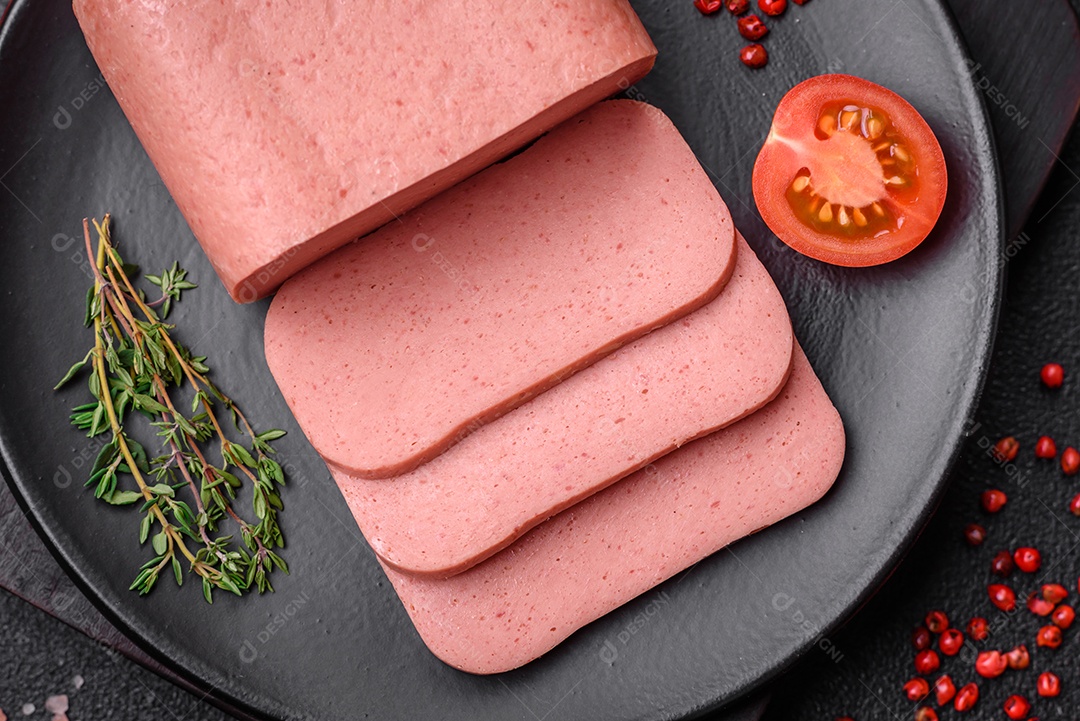 Delicioso presunto rosa enlatado com sal, especiarias e ervas sobre um fundo escuro de concreto