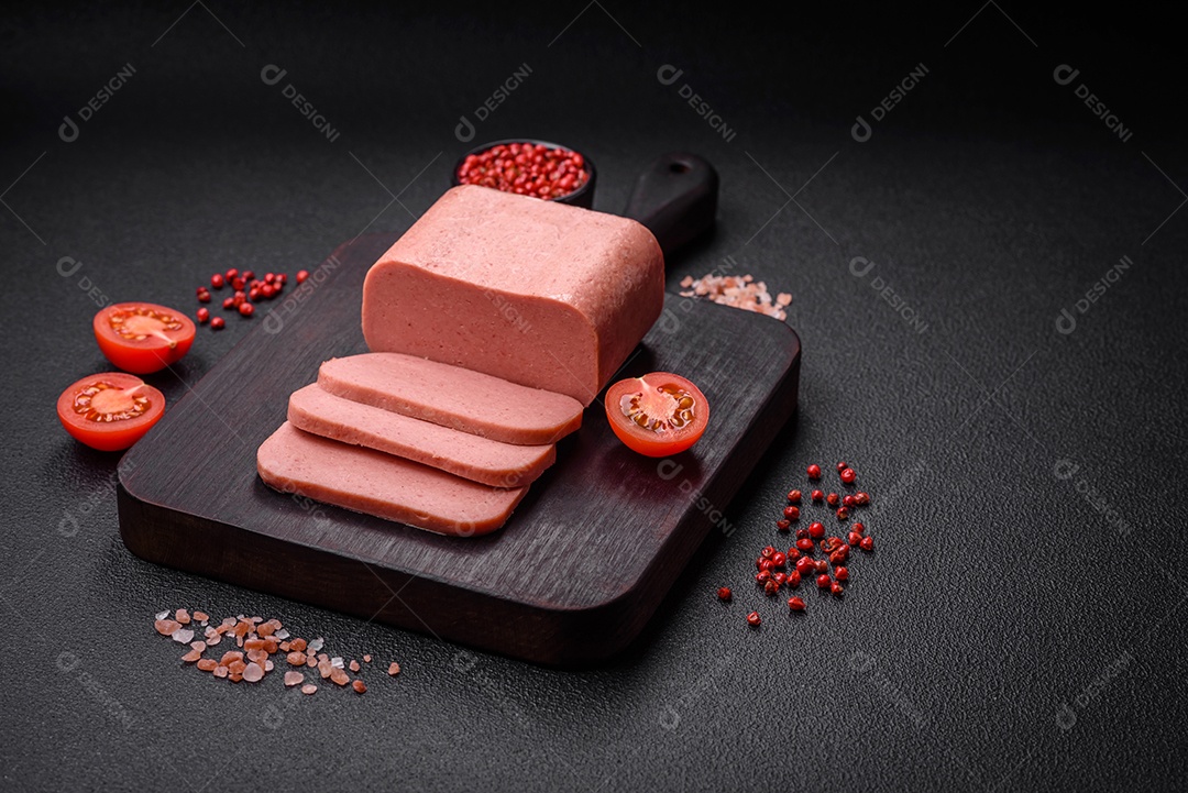 Delicioso presunto rosa enlatado com sal, especiarias e ervas sobre um fundo escuro de concreto