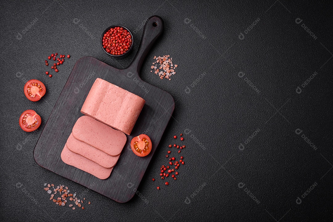 Delicioso presunto rosa enlatado com sal, especiarias e ervas sobre um fundo escuro de concreto