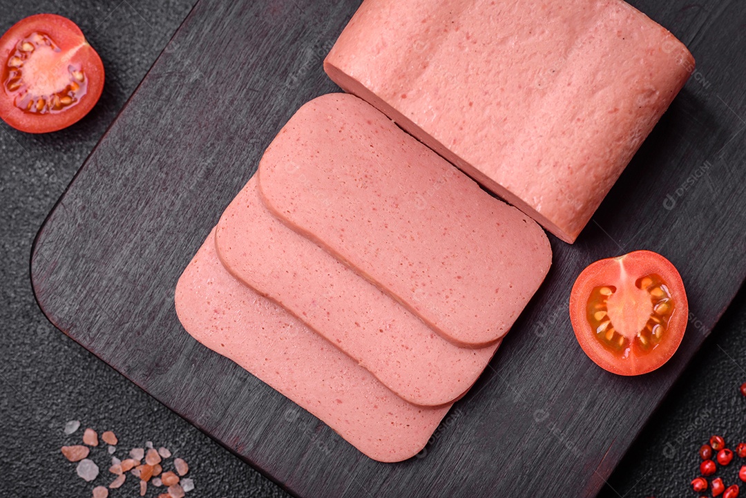 Delicioso presunto rosa enlatado com sal, especiarias e ervas sobre um fundo escuro de concreto