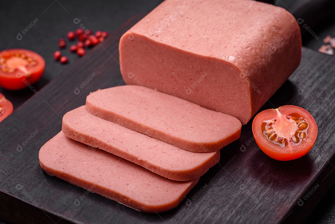 Delicioso presunto rosa enlatado com sal, especiarias e ervas sobre um fundo escuro de concreto