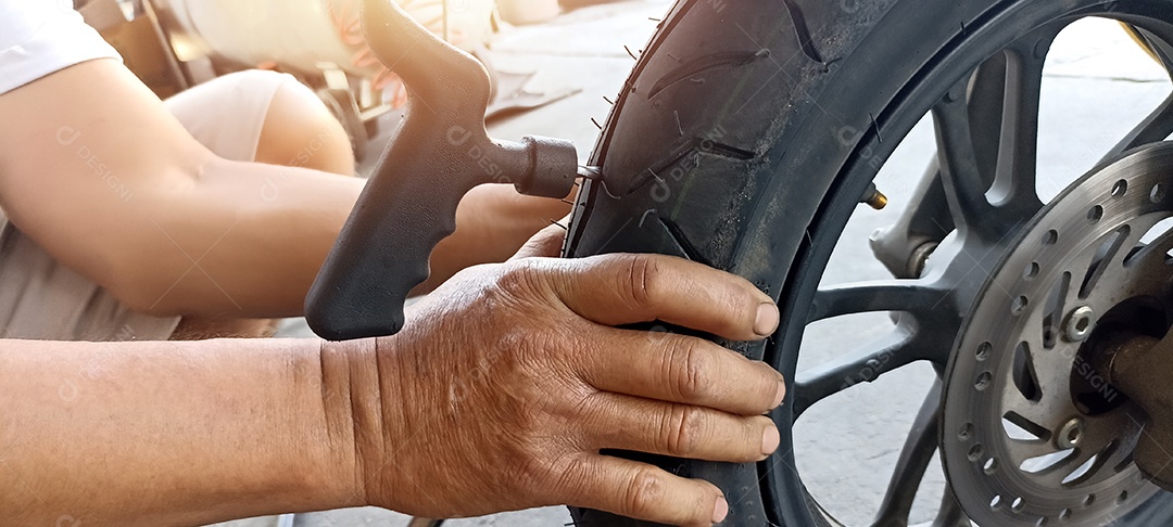 Um pneu de motocicleta está sendo consertado por causa de um furo