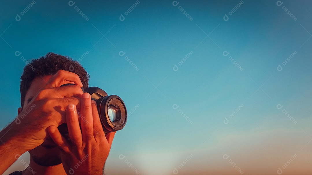 Fotógrafo no topo do edifício ao pôr do sol