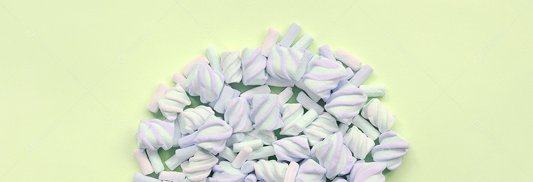 Muitos marshmallow colorido disposto em fundo de papel limão