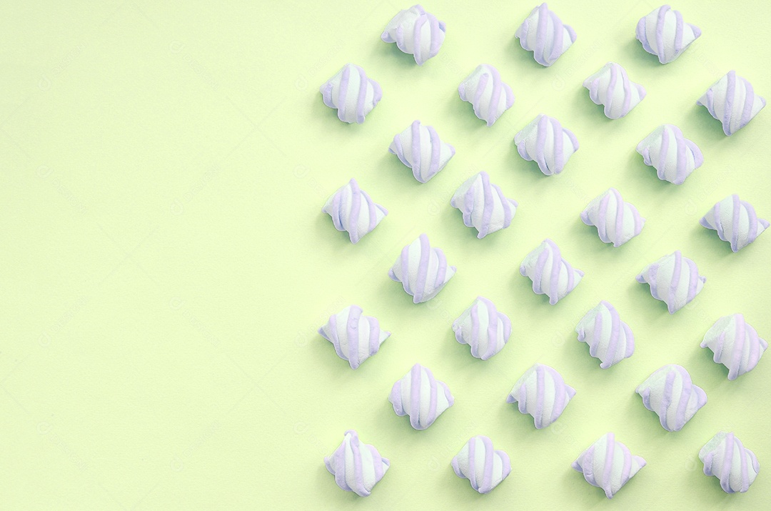 Marshmallow colorido disposto em fundo de papel limão