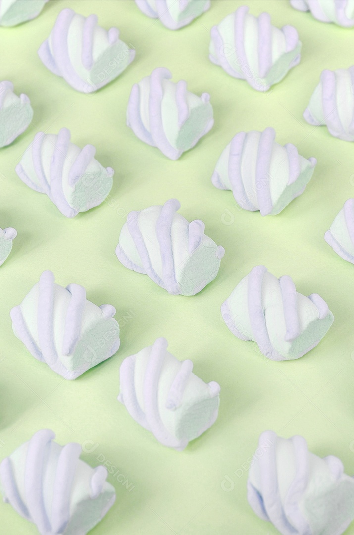 Marshmallow colorido disposto em fundo de papel limão