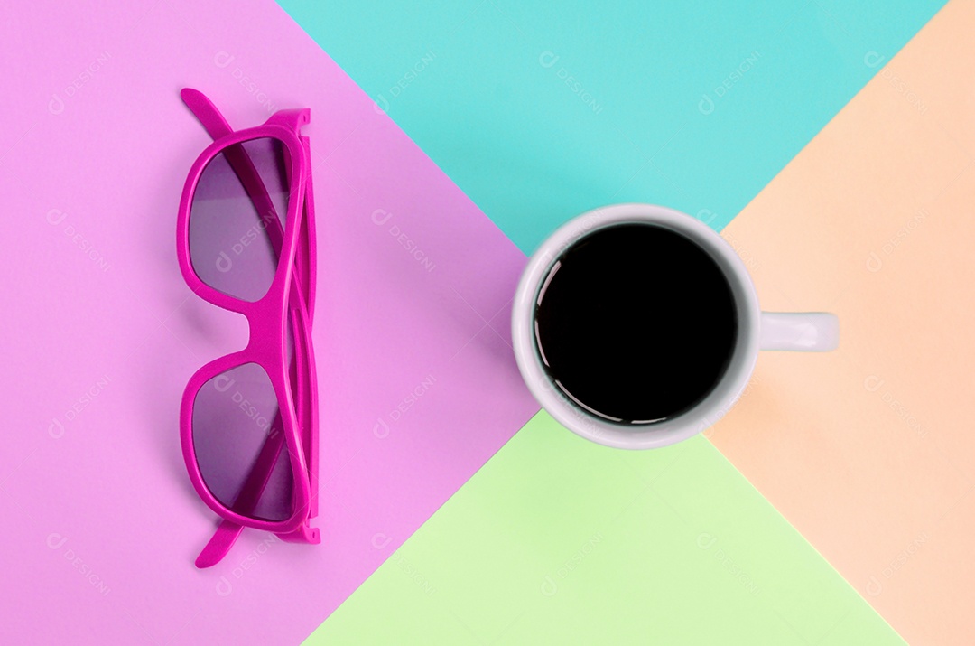Óculos de sol e xícara de café sobre fundo colorido de papel