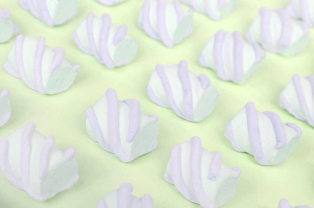 Marshmallow colorido disposto em fundo de papel limão