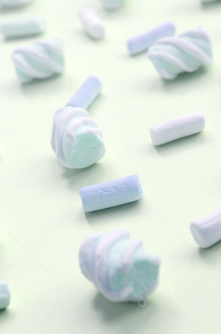 Marshmallow colorido disposto em fundo de papel limão