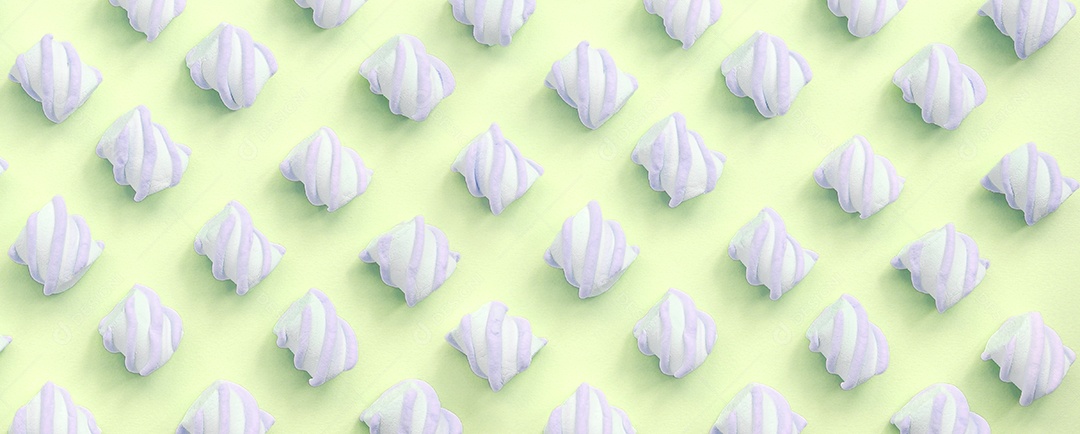 Marshmallow colorido disposto em fundo de papel limão