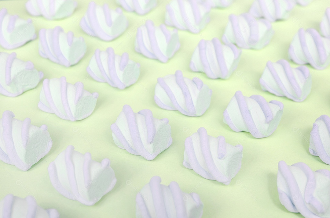 Marshmallow colorido disposto em fundo de papel limão