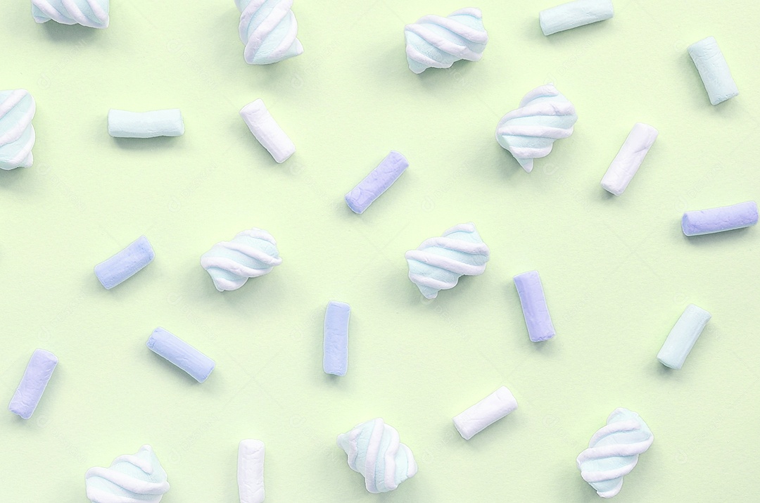 Marshmallow colorido disposto em fundo de papel limão