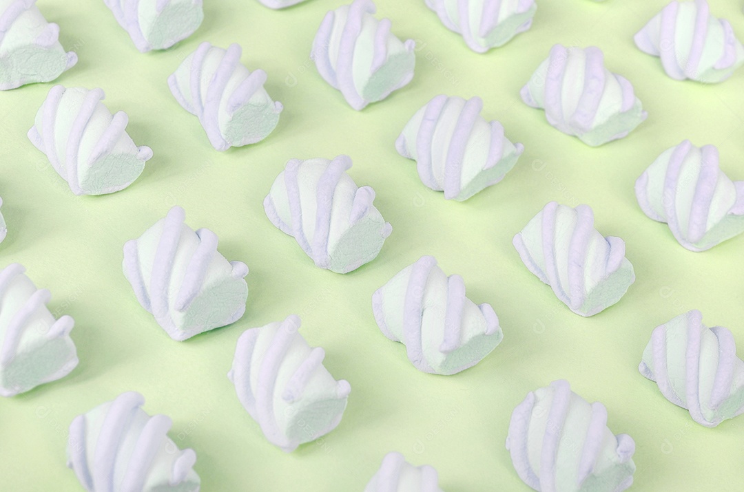 Marshmallow colorido disposto em fundo de papel limão