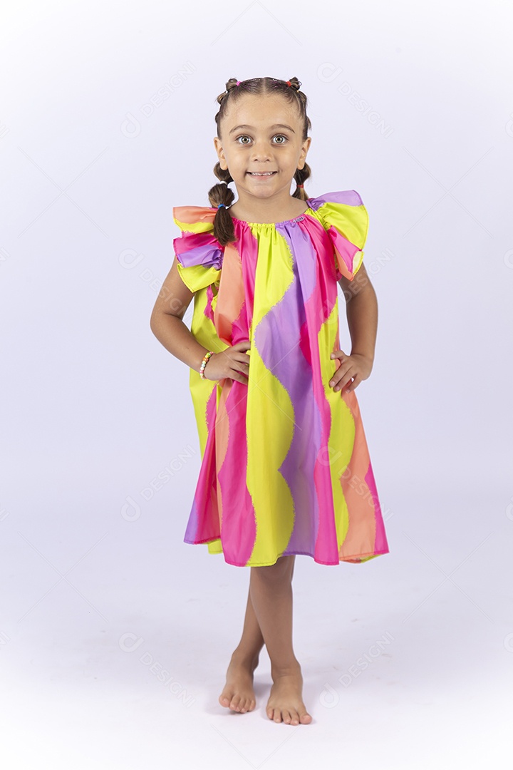 Menina sorridente usando vestido colorido sobre um fundo isolado branco.