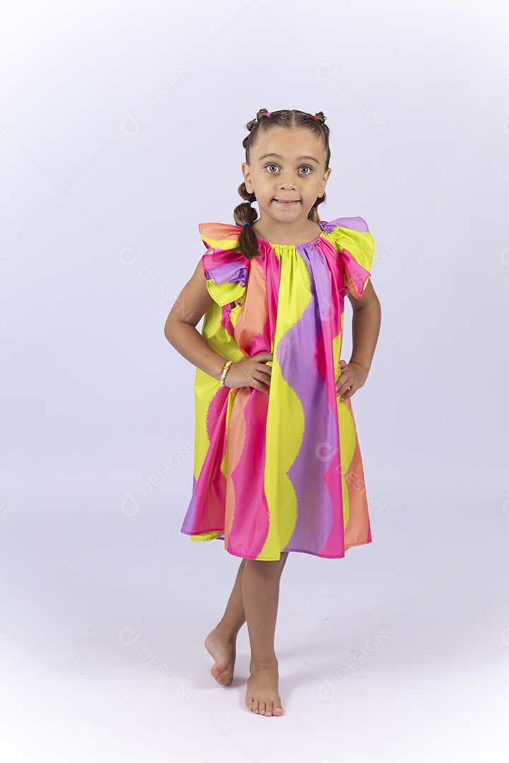 Menina sorridente usando vestido colorido sobre um fundo isolado branco.