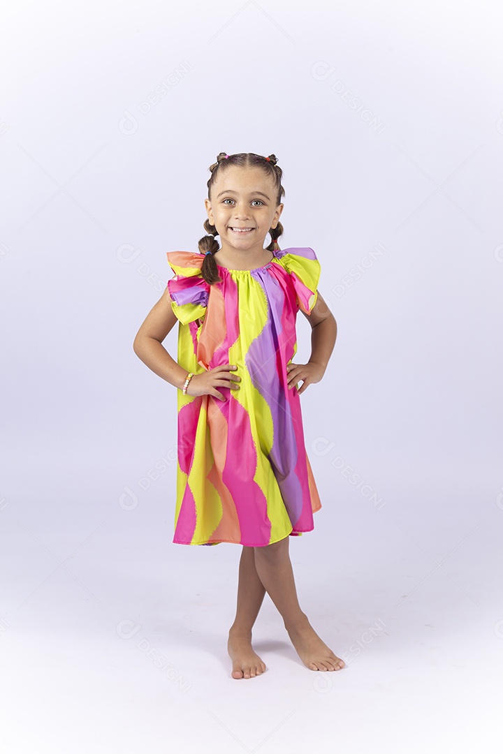 Menina sorridente usando vestido colorido sobre um fundo isolado branco.