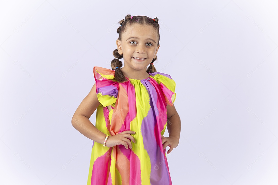 Menina sorridente usando vestido colorido sobre um fundo isolado branco.
