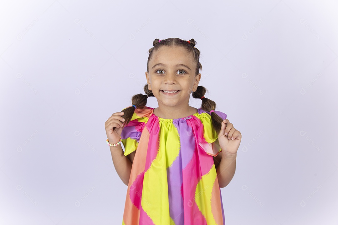 Menina sorridente usando vestido colorido sobre um fundo isolado branco.
