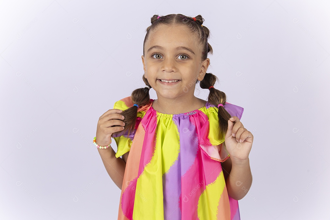 Menina sorridente usando vestido colorido sobre um fundo isolado branco.