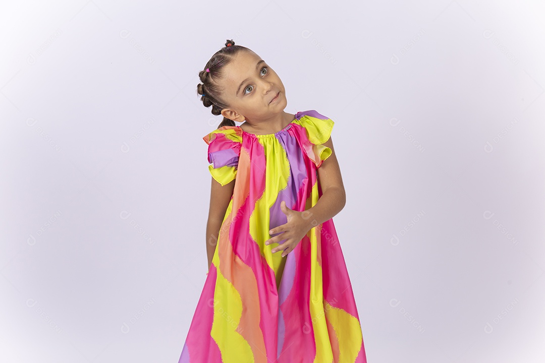 Menina sorridente usando vestido colorido sobre um fundo isolado branco.