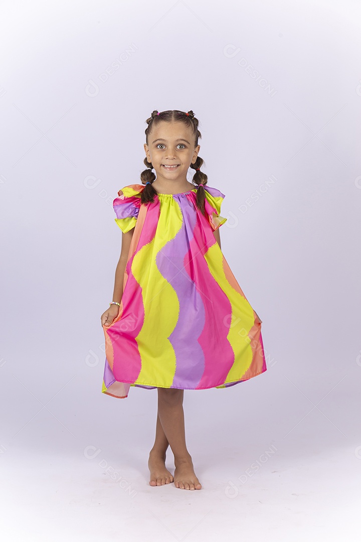 Menina sorridente usando vestido colorido sobre um fundo isolado branco.