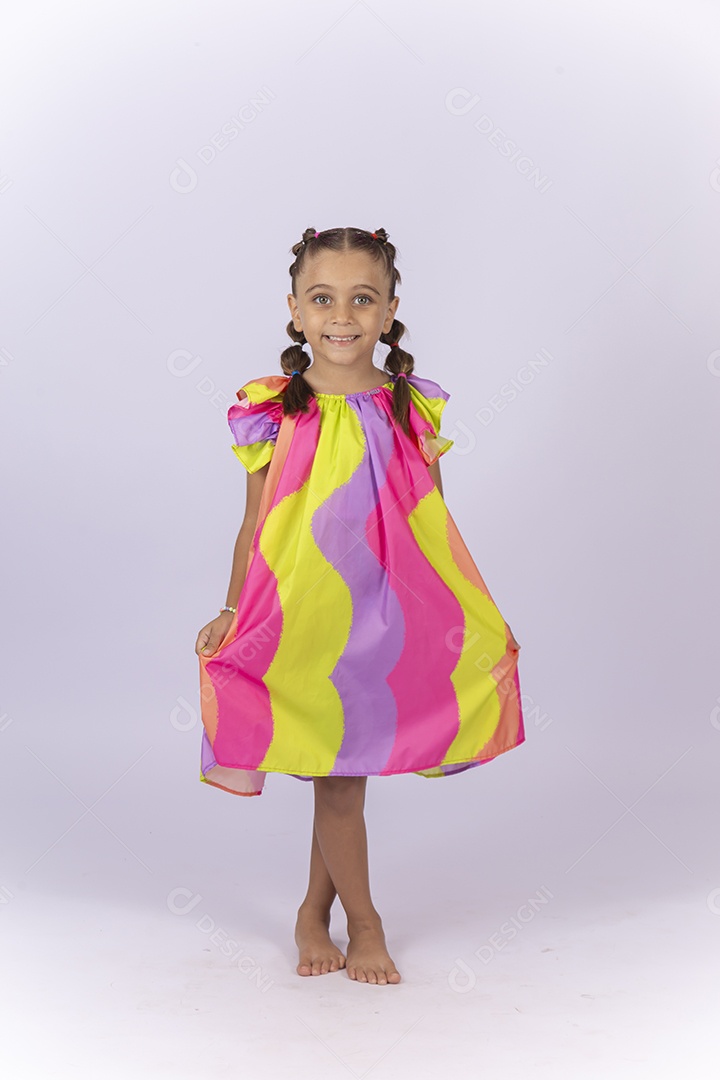 Criança vestida com um lindo vestido colorido sobre um fundo isolado branco.